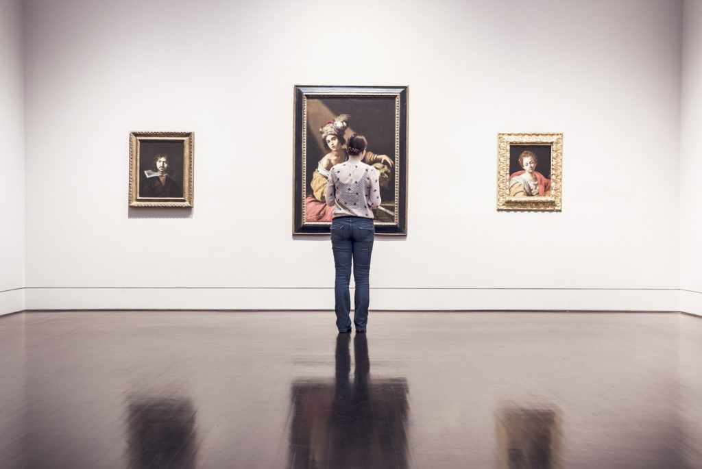 Persona che guarda un quadro in un museo
